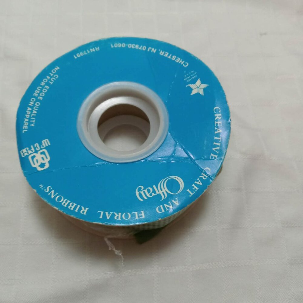 The remaining long length of a roll of vintage ribbon with an tiled pattern